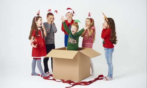 Children is surprised while opening christmas gift